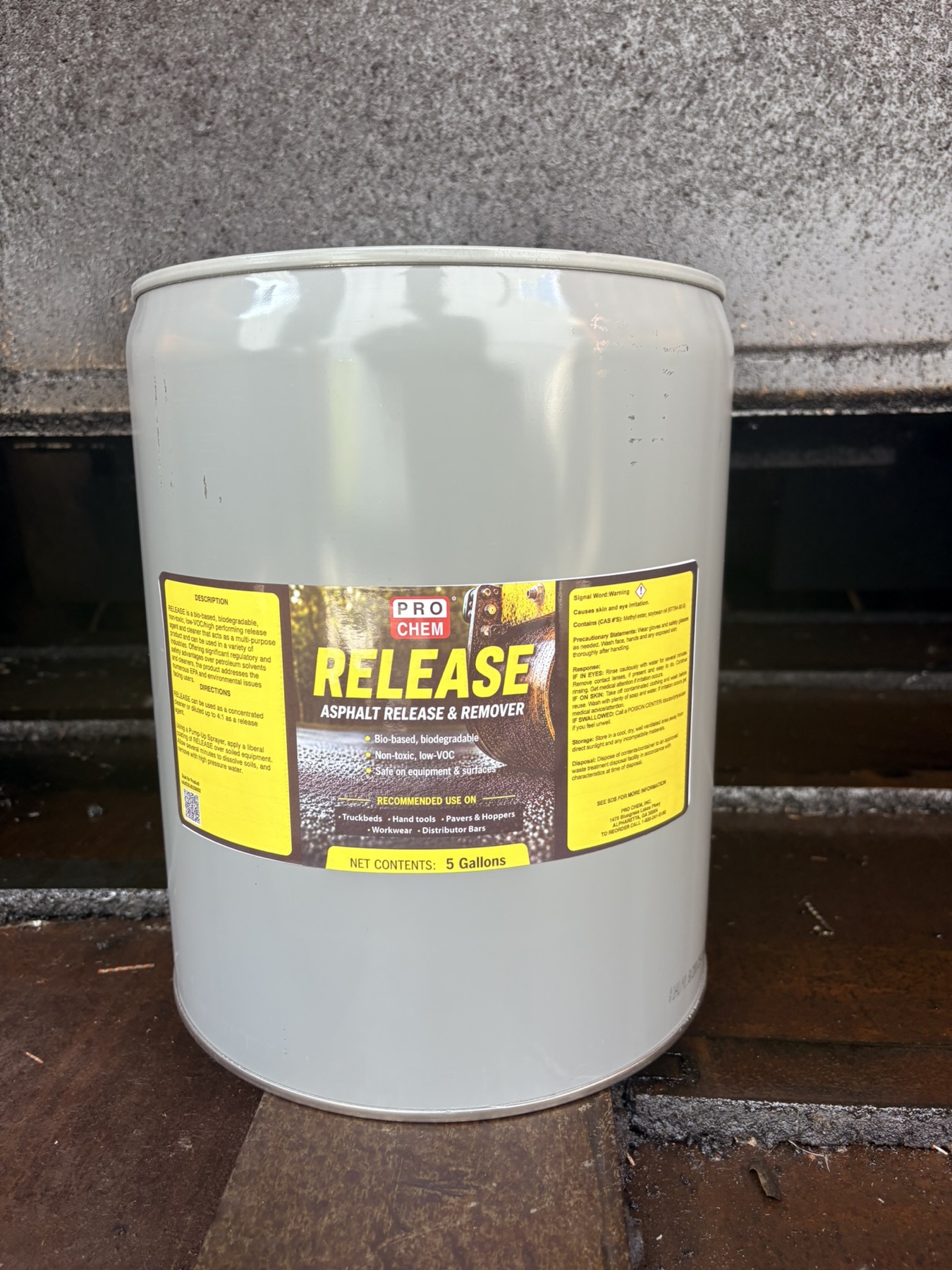 RELEASE 5-gallon pail photographed beside paving equipment